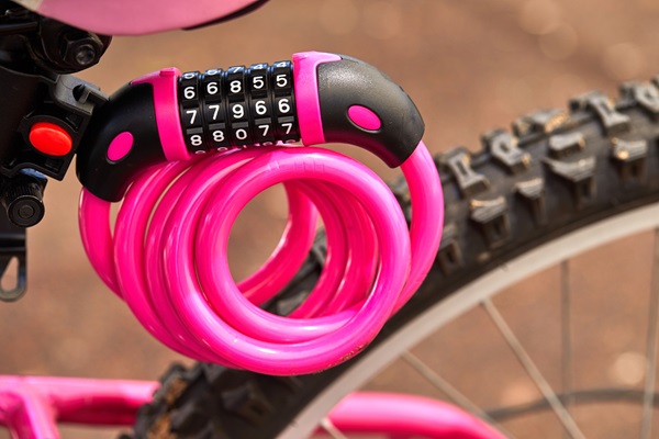 Close up van een roze slot, gemonteerd aan de zadel van een fiets