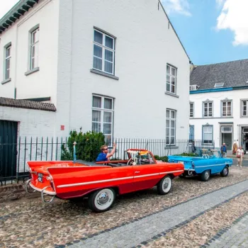 Oldtimers in het witte stadje Thorn, waar bezoekers genieten van een zonnige dag in het historische centrum