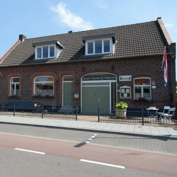 Gevel van ’t Smedenhuys in Maasbracht-Beek, voormalig smederijpand met bakstenen uitstraling en karakteristieke details.